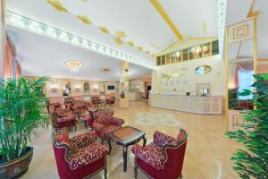 a lobby with a waiting room with chairs and tables at Versal Hotel in Voronezh