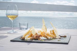 a plate of food on a table with a glass of wine at Hotel Cavalluccio Marino in Santa Marinella