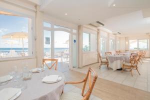 a dining room with tables and chairs and the ocean at Hotel Cavalluccio Marino in Santa Marinella