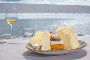 a plate of food on a table with a glass of wine at Hotel Cavalluccio Marino in Santa Marinella