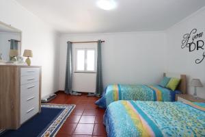 1 Schlafzimmer mit 2 Betten, einer Kommode und einem Spiegel in der Unterkunft Monte Mar House in Ribeira Grande