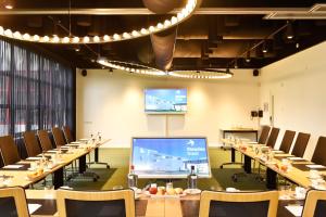 a conference room with long tables and chairs and a projection screen at Notiz Hotel Leeuwarden in Leeuwarden