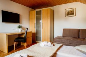 1 dormitorio con cama, escritorio y silla en Apartments Kristan, en Bled