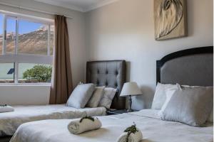 a hotel room with two beds and two lamps at Kingfisher Hollow in Gordonʼs Bay