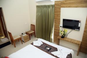 a hotel room with a bed and a television at Apollo Court (Apollo hospital,Sankara natralya, US consulate in Chennai