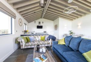 a living room with blue couches and a table at Bramble in Ansty