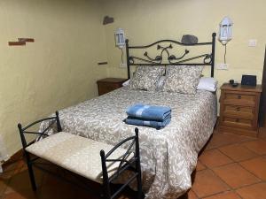 a bedroom with a bed and a chair with towels on it at complejo rural el prado in Logrosán +45 photos