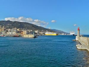 a large body of water with a lighthouse and a city at Maison d'Hôtes Bastia in Bastia +3 photos