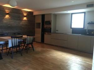 a room with a table and chairs and a kitchen at Maison d'hôtes Bastia in Bastia