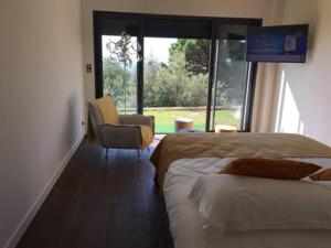 a bedroom with two beds and a chair and a window at Maison d'hôtes Bastia in Bastia