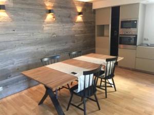 a table and chairs in a kitchen with a wooden wall at Maison d'hôtes Bastia in Bastia