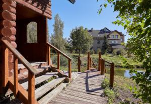 een houten brug met een huis op de achtergrond bij HOT SPRINGS in Soezdal