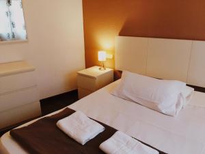 a bedroom with a white bed with two towels on it at Coroa Ayuntamiento in Valencia