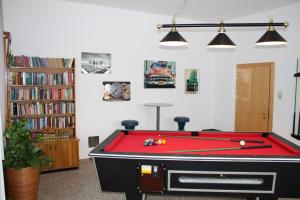 a living room with a pool table and books at Hotel Hubertus in Mallnitz