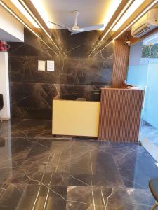 a lobby with a yellow counter and a stone wall at Nova Park in Rajkot