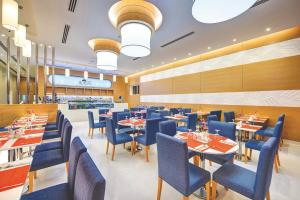 杜拜的住宿－杜拜阿爾庫利因布爾酒店，一间配备有桌子和蓝色椅子的用餐室
