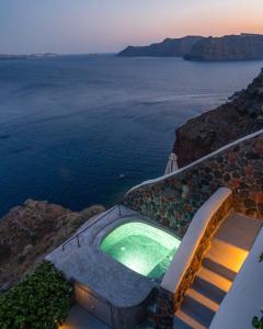 a swimming pool with a view of the ocean at Pezoules of Oia in Oia