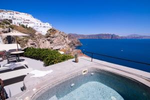 a swimming pool with a view of the ocean at Pezoules of Oia in Oia