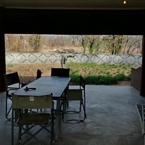 a table and chairs with a view of a giraffe at Bush Camp Phalaborwa in Phalaborwa