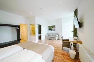 ein Hotelzimmer mit einem Bett und einem Sofa in der Unterkunft Hotel Grüner Baum in Hamm