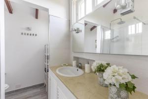 プエルト・デ・ラ・クルスにあるLa Casita de Los Orovalesの洗面台と鏡のある白いバスルーム +20枚の写真