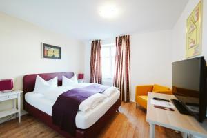 une chambre d'hôtel avec un lit et une télévision dans l'établissement Hotel Grüner Baum, à Hamm