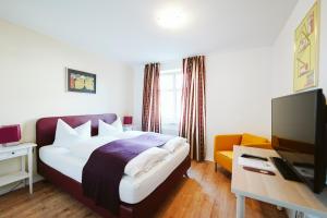 a hotel room with a bed and a television at Hotel Grüner Baum in Hamm