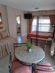 uma sala de estar com uma mesa e duas camas em Maison Apart Hotel em Mar del Plata
