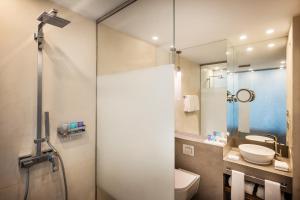 a bathroom with a shower and a toilet and a sink at Sheraton Baku Intourist in Baku