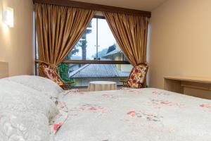 a bedroom with a bed and a large window at Hotel Park Haus in Nova Petrópolis