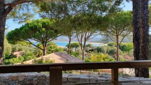 a view of the ocean from a wooden fence at Résidence & Hotel U Livanti ECOLABEL in Propriano