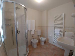 a bathroom with a shower and a toilet and a sink at Casale in Collina in Capriva del Friuli