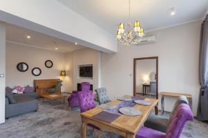 - un salon avec une table en bois et des chaises violettes dans l'établissement Hotel Mikulski, à Gliwice