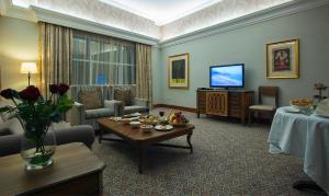 a living room with a table and a television at Ayla Hotel in Al Ain +18 photos