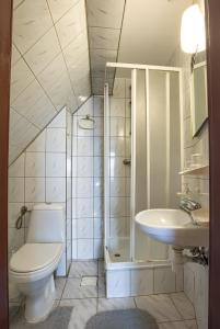 a white bathroom with a toilet and a sink at Zajazd Czorsztyński in Maniowy