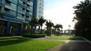 a large apartment building with a lawn in front of it at The Relaxing Room Sea View at Lumpini Park Beach Jomtien Condominium Pattaya in Jomtien Beach
