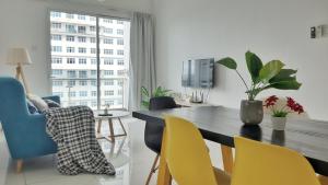 a dining room with a table and yellow chairs at No.11 The John @ Puchong Skypod Residence in Puchong