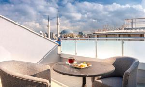 einen Tisch und Stühle auf einem Balkon mit einer Obstschale in der Unterkunft Hotel Bossuite Business in Istanbul