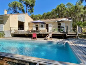 a house with a swimming pool in front of a house at Villa les Mimosas with pool and fantastic views in Lacanau