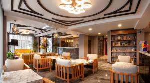 restauracja ze stołami i krzesłami oraz sufitem w obiekcie Hotel Bossuite Business w Stambule