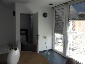 uma sala de estar com uma mesa e uma porta de vidro em Holiday Home Ieper Market Square em Ypres