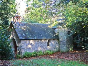 a small stone house with a roof with a bell at Manoir de Trégaray in Sixt-sur-Aff