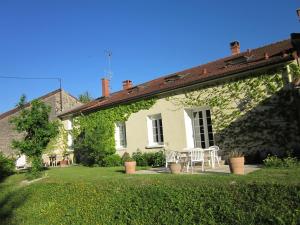 une maison blanche avec une table et des chaises dans la cour dans l'établissement Au Pré du Moulin, à Clamanges