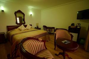 a bedroom with a bed and a table and a chair at Treasure Cove Hotel & Restaurant in Bel Ombre