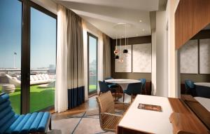 a dining room with a table and chairs and a large window at Sheraton Baku Intourist in Baku