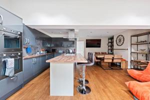 a kitchen with a bar and a living room at NEW Bright & Stylish 4BD Home City Centre of Leeds in Leeds