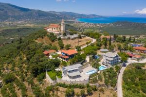 una vista aérea de una casa en una colina junto al océano en Demargia Villa en Áno Yerakaríon