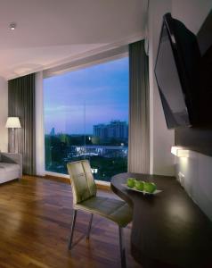 a living room with a table and a large window at favehotel Graha Agung Surabaya in Surabaya