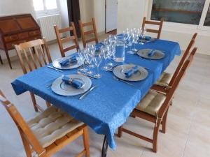 une table bleue avec des assiettes et des verres dans l'établissement Domaine de l'Estuaire, à Saint-Thomas-de-Cônac