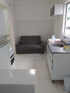 Una cocina con un sofá en la esquina de una habitación. en Apartamento no centro - 2, en Balneário Camboriú 6 fotos más